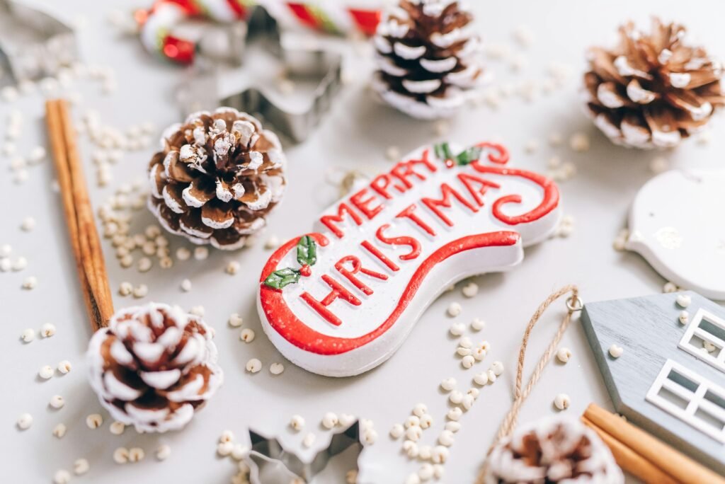 Close-up of festive Christmas decorations with pine cones and ornaments on a white background.