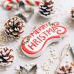 Close-up of festive Christmas decorations with pine cones and ornaments on a white background.