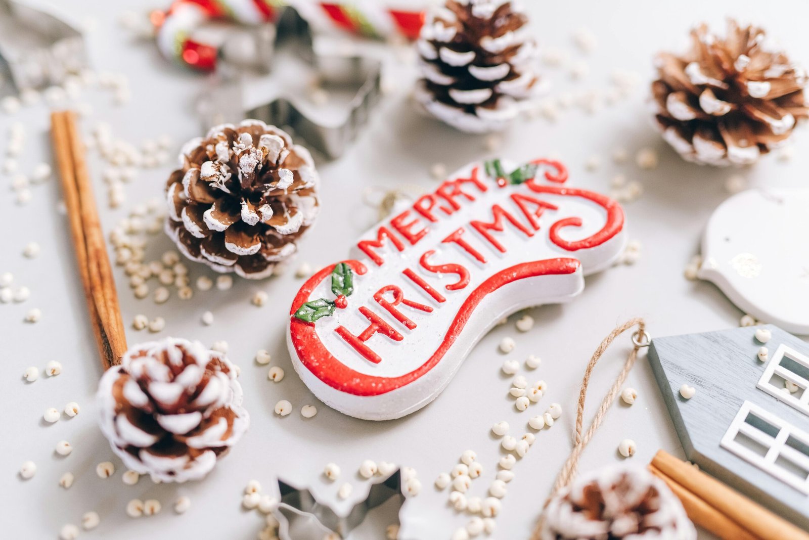 Close-up of festive Christmas decorations with pine cones and ornaments on a white background.