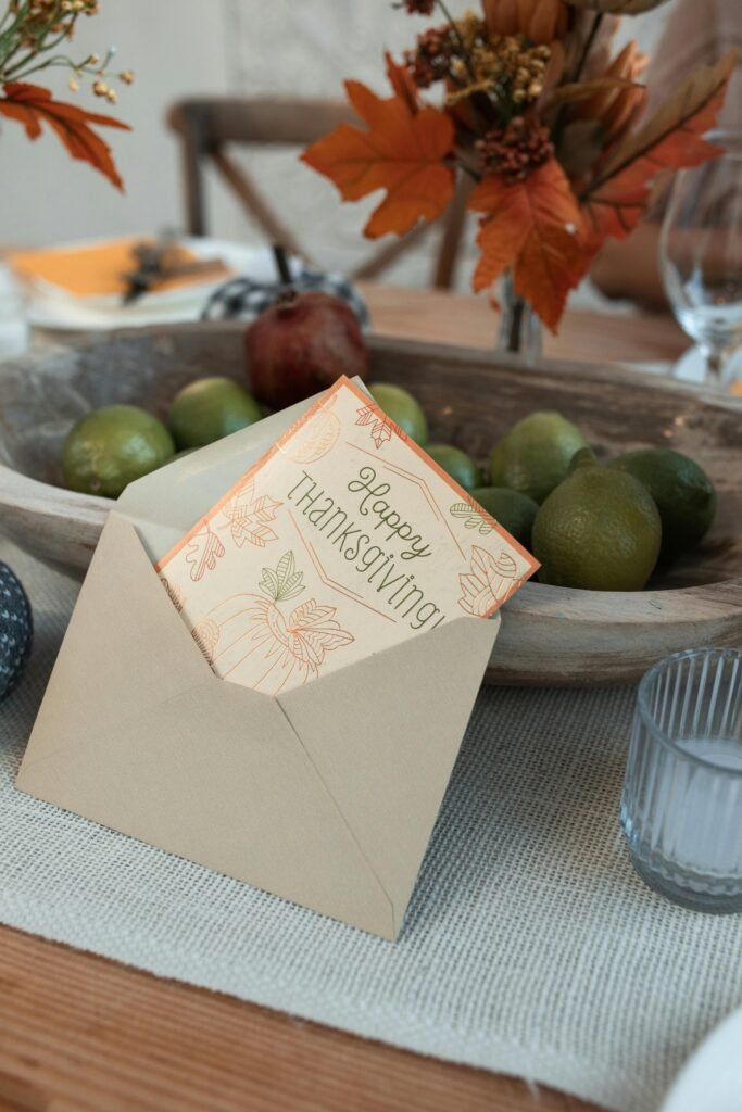 Thanksgiving card displayed with autumn fruits and decor creating a festive table setting.