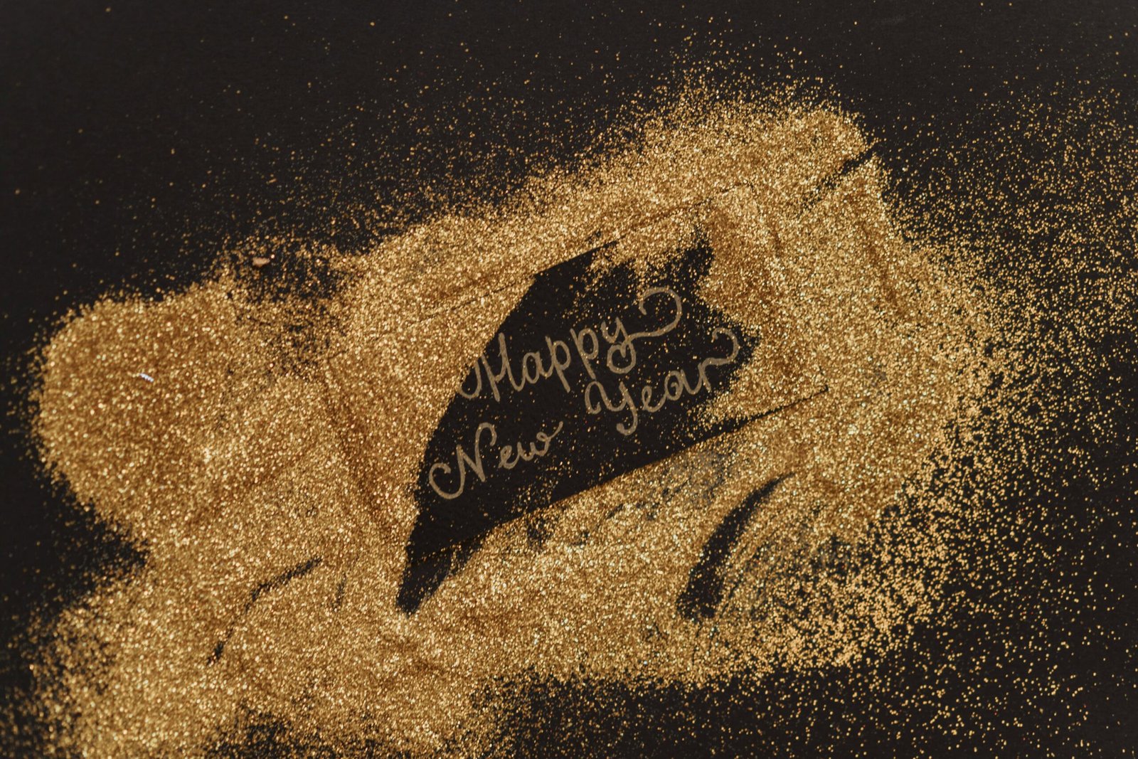 A festive greeting with glitter and cursive lettering spelling 'Happy New Year'. Perfect for seasonal celebrations.
